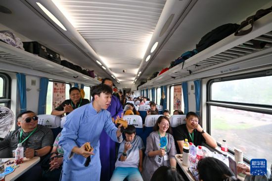 9月7日,相声演员在S910列车上为旅客表演快板。