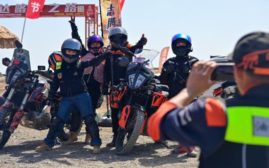 2024年5月1日,在新疆克拉玛依市乌尔禾区世界魔鬼城景区,车友在自驾线路起点合影。新华社记者 丁磊 摄
